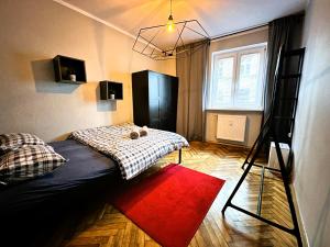 a bedroom with a bed and a ladder and a red rug at Apartament Vincent in Toruń