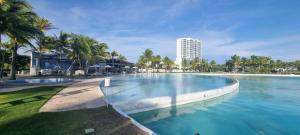 una gran piscina con un edificio en el fondo en Amplio y Bello Estudio en Town Center Playa Blanca, Rio Hato, en Río Hato