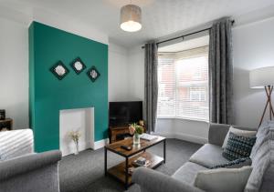 a living room with a couch and a green wall at * Parking * Sleeps 5 * Fast Wi-Fi in Lincolnshire