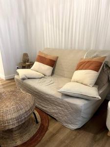 un sofá blanco con almohadas en una habitación en Jolie maison avec courette, en Bourges