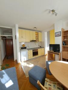 a kitchen with yellow cabinets and a table and chairs at Ramonda in Belgrade