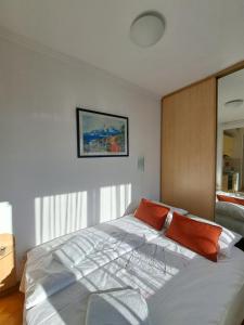 a bedroom with a large white bed with orange pillows at Ramonda in Belgrade