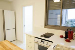 een keuken met een witte koelkast en een fornuis bij Waves Project in Akko