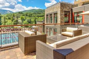 a balcony with wicker furniture and a view of the mountains at Eagle River by AvantStay Located in the Westin in Avon