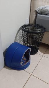 a blue hat on the floor next to a trash can at Apto de 2 quartos com AR localizado no centro sul in Santo Ângelo