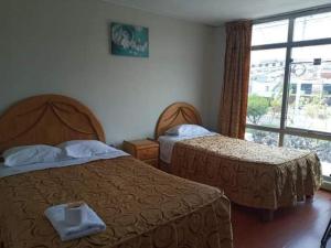 a hotel room with two beds and a window at HOTEL AREQUIPA ANDINOS in Arequipa