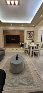 sala de estar con sofá y TV en New Bazar Luxury Apartment, en Tirana