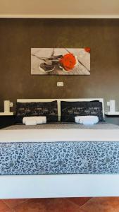 een slaapkamer met een bed met een schilderij aan de muur bij Room24 in Genzano di Roma