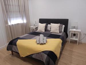 1 dormitorio con 1 cama con 2 toallas en habitacion con baño privado en un piso con familia en Santa Cruz de la Palma