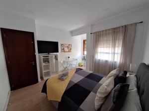 ein Schlafzimmer mit einem Bett und einem Sofa in der Unterkunft habitacion con baño privado en un piso con familia in Santa Cruz de la Palma