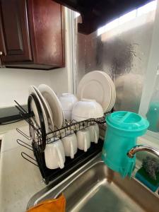 a dish rack filled with plates and cups on a kitchen sink at Casa para vacacionar in Cabo San Lucas