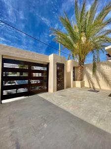 a house with a palm tree in front of it at Casa para vacacionar in Cabo San Lucas