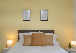 ein Schlafzimmer mit einem Bett mit drei Bildern an der Wand in der Unterkunft * Parking * Sleeps 5 * Fast Wi-Fi in Lincolnshire