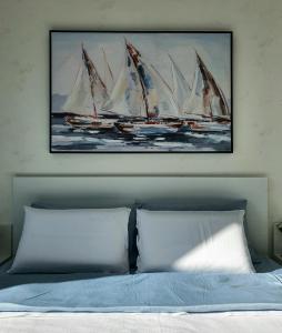a painting of sail boats on a wall above a bed at Negotin Centar Apartman II in Negotin