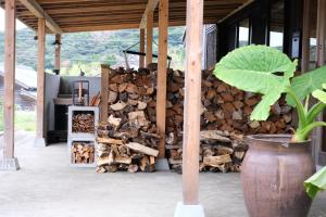 a pile of fire wood in front of a building at 菜を｜NAWO in Goto