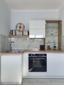 a kitchen with white cabinets and a sink at Negotin Centar Apartman II in Negotin