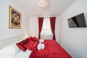 um quarto com uma cama com toalhas vermelhas e brancas em Rooms&Apartments Tomić em Ston