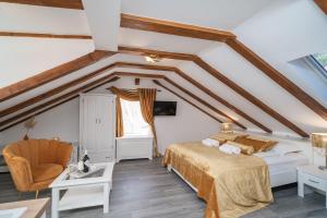 - une chambre mansardée avec un lit et une chaise dans l'établissement Rooms&Apartments Tomić, à Ston