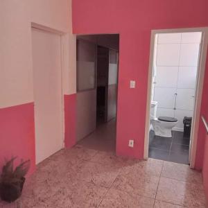 Habitación con paredes rojas y baño con aseo. en Pousada VIDA en Pelotas