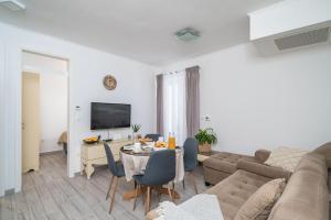 - un salon avec un canapé et une table dans l'établissement Rooms&Apartments Tomić, à Ston