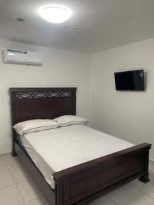 uma cama num quarto com uma televisão na parede em Hermoso Apartamento con una de las mejores vistas na Cidade do Panamá