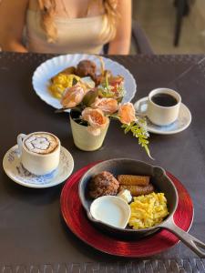a table with plates of food and cups of coffee at Hotel y Café Ixmati Suchitoto in Suchitoto
