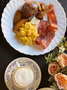 a plate of breakfast foods and a cup of coffee at Hotel y Café Ixmati Suchitoto in Suchitoto