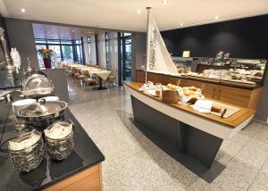 un restaurant avec un buffet et un bateau sur le comptoir dans l'établissement Hotel Hagnauer Seeperle, à Hagnau am Bodensee