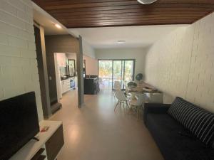a living room with a couch and a table at Paúba · Paúba Beach House -Em lindo condomínio c/ piscina in São Sebastião