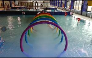 a rainbow colored slide in a swimming pool at Gael Stary Rynek 1 in Elblag