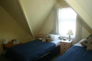 a attic bedroom with two beds and a window at Guesthouse 24-7 The Old Knoll Guesthouse in Newport