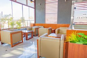 a waiting room with chairs and tables and windows at Hotel San Lorenzo in Moquegua