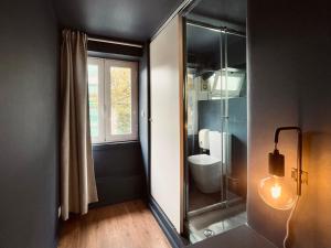 a bathroom with a toilet and a glass shower at Avenue Hostel & Suites in Lisbon +9 photos