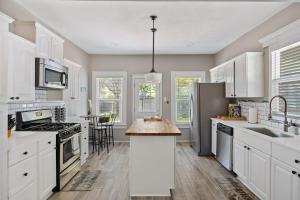 uma cozinha com armários brancos e uma ilha de cozinha em Charming Craftsman close by Bishop Arts & Downtown em Dallas