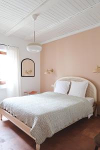 a white bedroom with a large bed with white sheets at Appartement cosy sur la route des vins d'Alsace in Dambach-la-Ville
