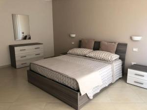 een slaapkamer met een groot bed en een dressoir bij Il Belvedere di Nonna Vincenza - Taormina side in Piedimonte Etneo