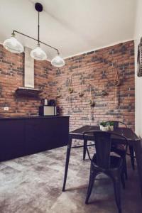 a dining room with a table and a brick wall at Studio Cosy Tout Confort Porte Orléans 2 Pers Paris in Montrouge
