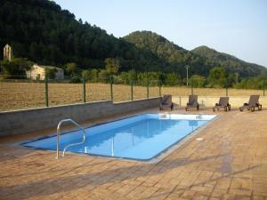 a swimming pool with two chairs at Can Carreras in Albanya