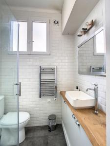 a white bathroom with a sink and a toilet at Studio Cosy Tout Confort Porte Orléans 2 Pers Paris in Montrouge