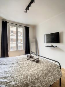 a bedroom with a bed and a flat screen tv at Studio Cosy Tout Confort Porte Orléans 2 Pers Paris in Montrouge