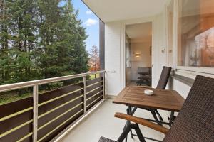 eine Veranda mit einem Holztisch und Stühlen auf dem Balkon in der Unterkunft LITTLE WINTERBERG Zentrale Lage Bikepark und Piste in Winterberg