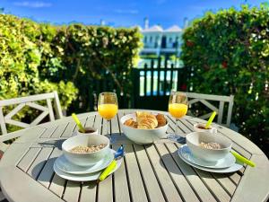 een tafel met kommen eten en glazen sinaasappelsap bij Bungalow Dunaflor Verde 5 by SunHousesCanarias in Maspalomas