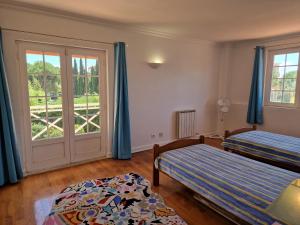 een slaapkamer met twee bedden en een raam bij RENT4REST GOLF LOVERS PARADISE 4BR VILLA WITH Pool in Sintra +53 foto's