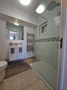 een badkamer met een glazen douche en een toilet bij RENT4REST GOLF LOVERS PARADISE 4BR VILLA WITH Pool in Sintra
