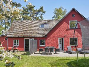 eine rote Scheune mit einem Picknicktisch davor in der Unterkunft Holiday home Nexø XLI in Neksø
