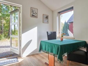 ein Esszimmer mit einem grünen Tisch und einem Fenster in der Unterkunft Holiday home Nexø XLI in Neksø
