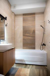 a bathroom with a tub and a sink at Unique Apartments in Pristina