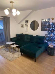 a living room with a green couch and a christmas tree at Apartmán Klára in Terchová