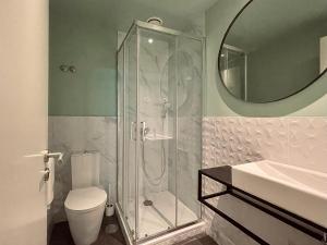 a bathroom with a shower and a toilet and a sink at Avenue Hostel & Suites in Lisbon +14 photos