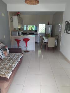a living room and kitchen with a couch and a table at Imóvel com 02 quartos próxima ao Morro do Macaco in Bombinhas